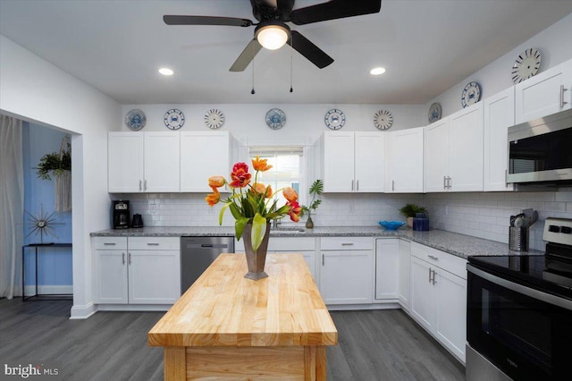 kitchen featuring wood counters, dark hardwood / wood-style floors, white cabinets, and appliances with stainless steel finishes