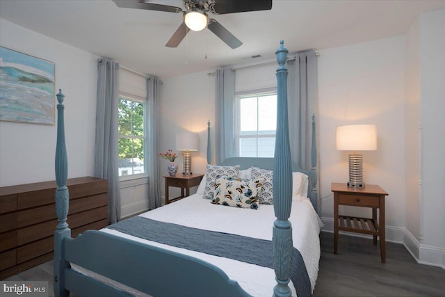 bedroom with multiple windows, dark wood-type flooring, and ceiling fan