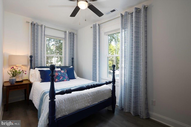 bedroom featuring multiple windows, dark hardwood / wood-style flooring, and ceiling fan