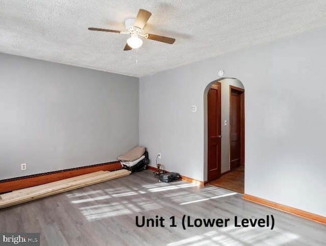 spare room with ceiling fan, hardwood / wood-style floors, and a textured ceiling