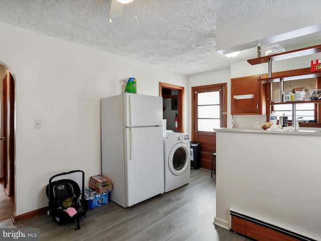 laundry area featuring a baseboard radiator, washer / dryer, a textured ceiling, and light wood-type flooring