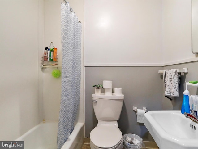 full bathroom with sink, shower / bath combination with curtain, and toilet