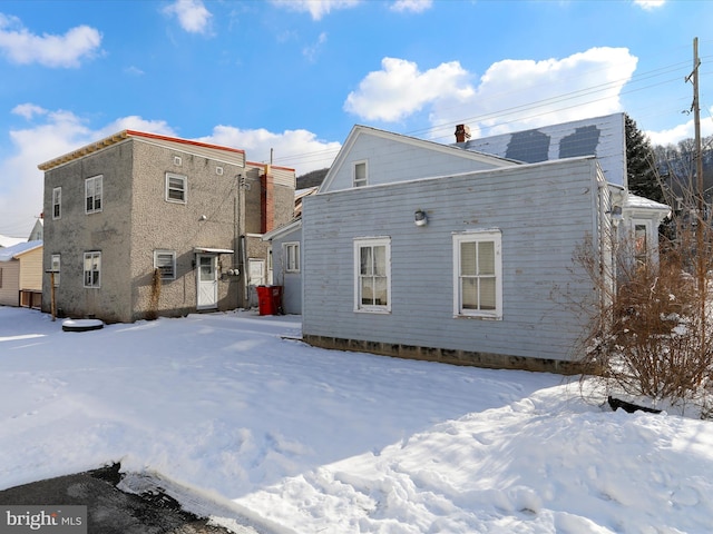 view of snow covered rear of property