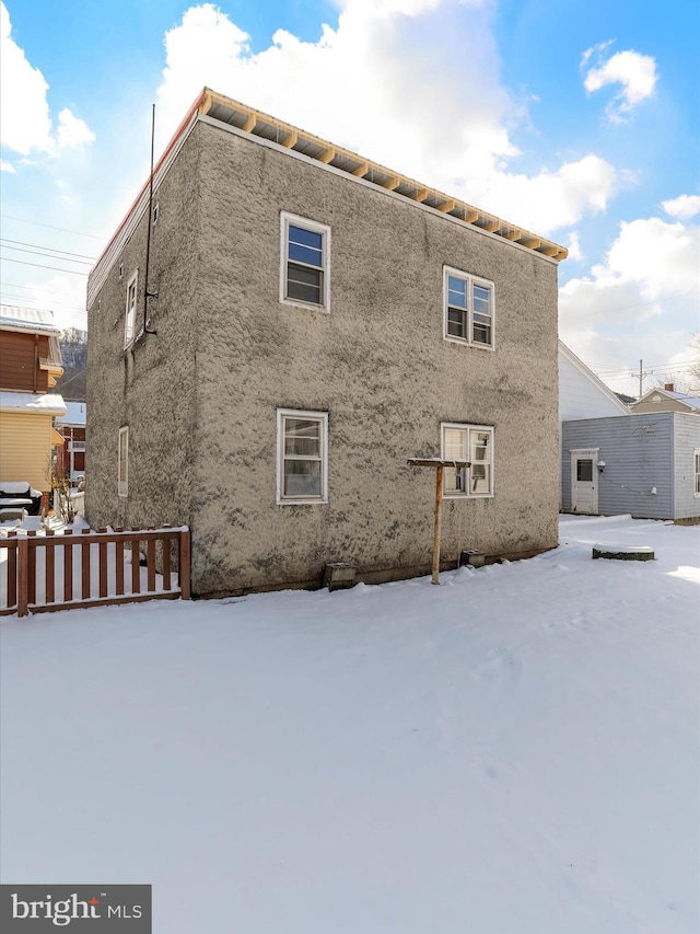 view of snow covered back of property