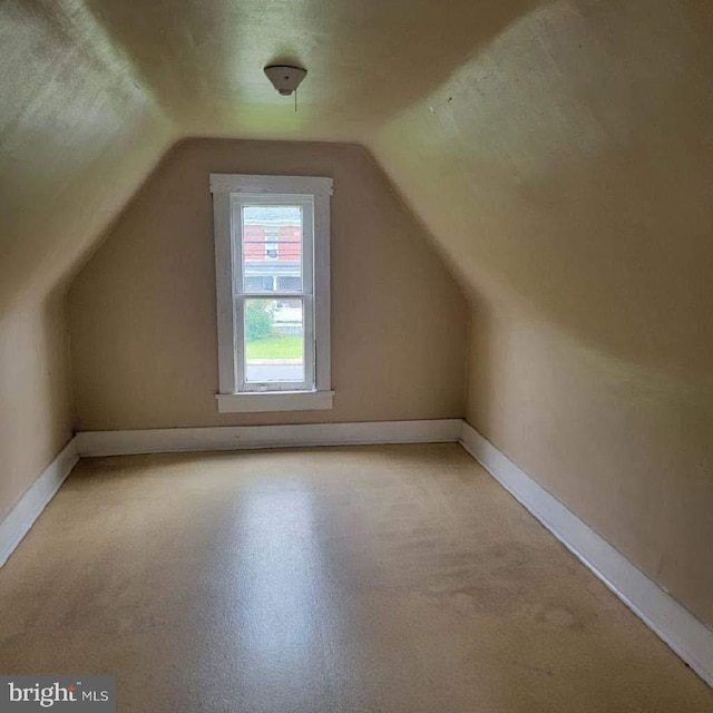 additional living space featuring vaulted ceiling and a textured ceiling