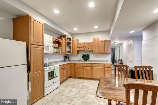 kitchen with light tile patterned flooring, sink, and white appliances