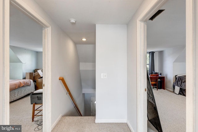 hallway featuring light colored carpet