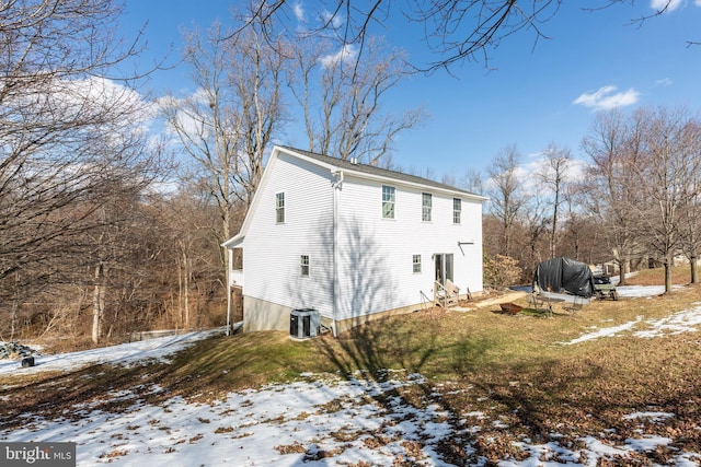 snow covered property with cooling unit