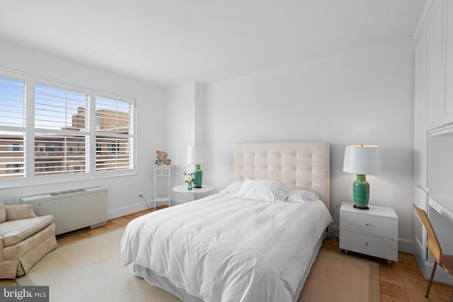 bedroom featuring light parquet flooring and radiator