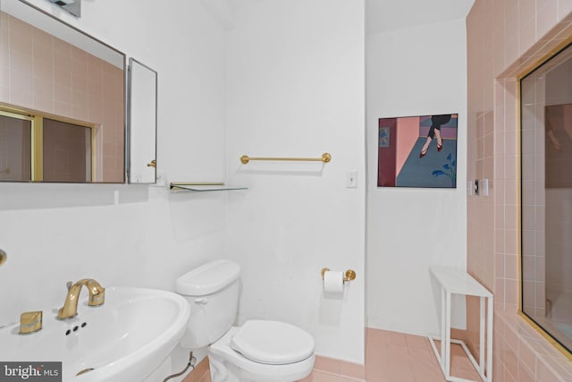 bathroom with sink, a shower with door, tile patterned floors, and toilet