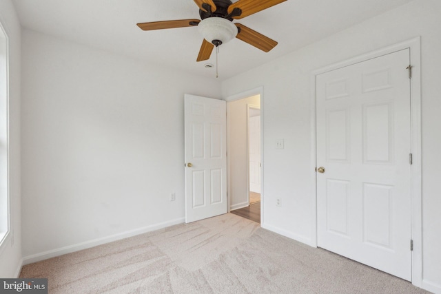 unfurnished bedroom featuring light colored carpet and ceiling fan