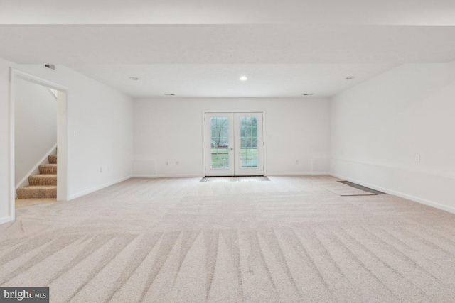 carpeted spare room featuring french doors