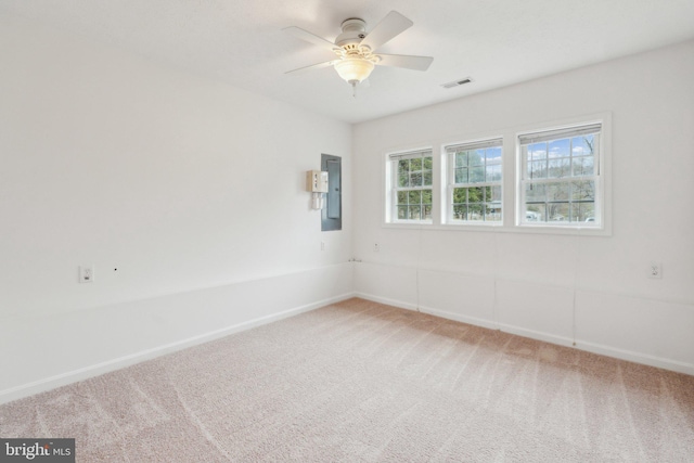 spare room with electric panel, ceiling fan, and carpet