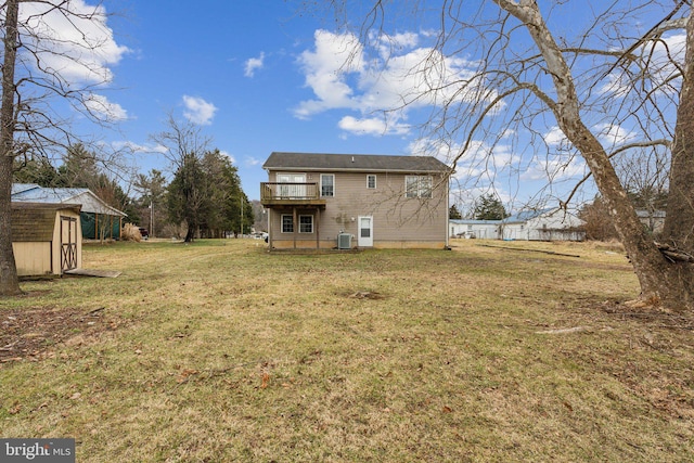 rear view of property featuring a wooden deck, a yard, cooling unit, and a storage unit