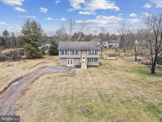 raised ranch with a storage shed and a front lawn