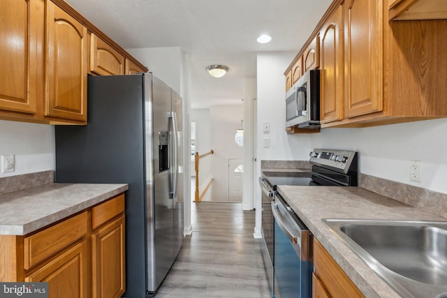 kitchen with sink, light hardwood / wood-style floors, and appliances with stainless steel finishes