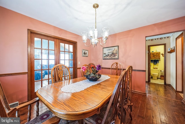 dining space featuring an inviting chandelier and dark hardwood / wood-style flooring