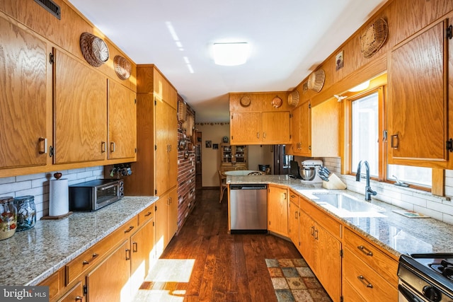 kitchen with sink, dark wood-type flooring, black gas range, decorative backsplash, and stainless steel dishwasher