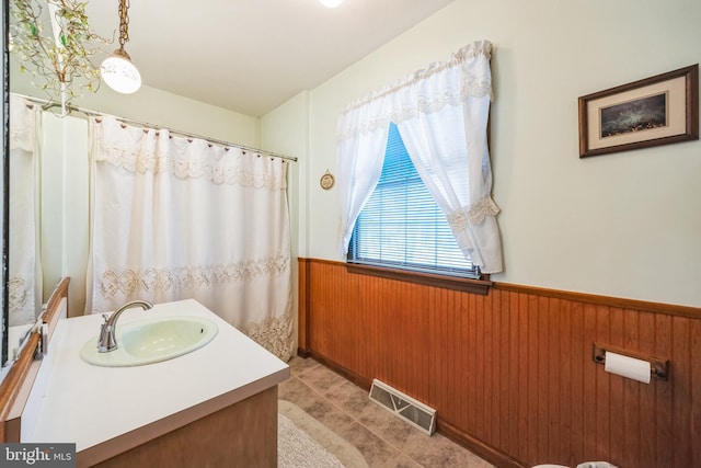 bathroom with vanity and wood walls