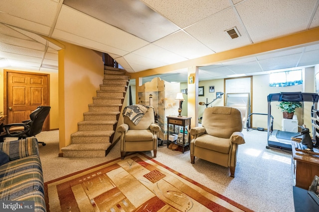 living room with a paneled ceiling and carpet