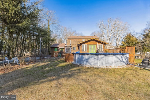 rear view of house with a swimming pool side deck and a yard