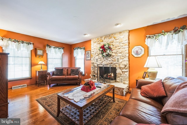 living room featuring a healthy amount of sunlight, hardwood / wood-style floors, and a fireplace