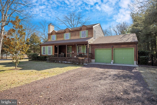 view of front facade featuring a garage, a front yard, and a porch