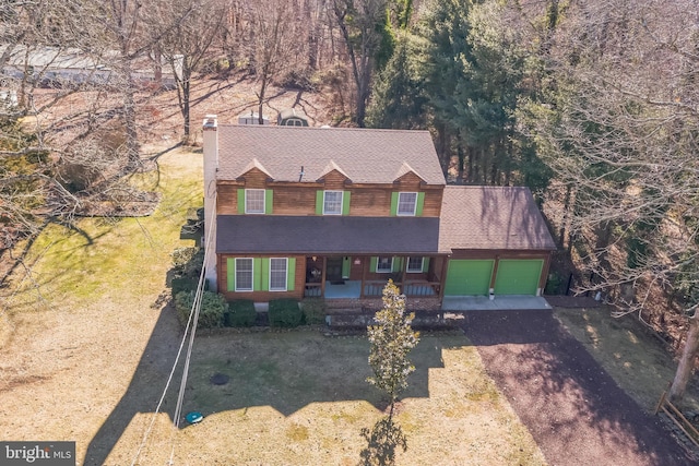 view of front of house with a garage, a porch, and a front yard