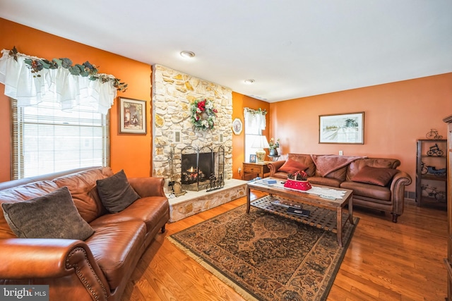 living room featuring hardwood / wood-style flooring and a stone fireplace