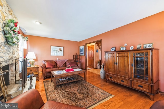 living room with a fireplace and light wood-type flooring