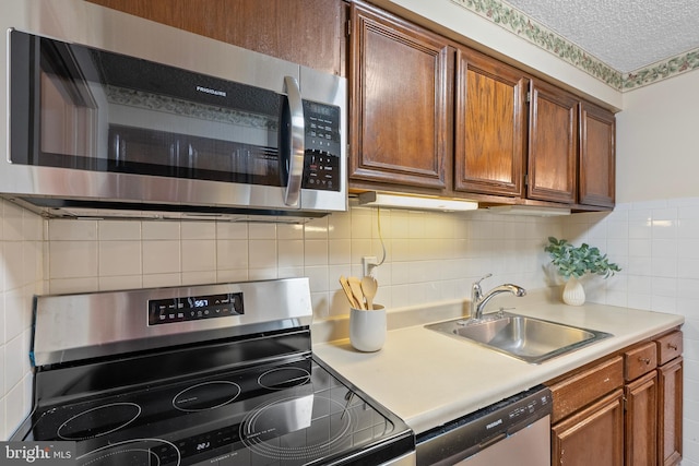 kitchen with sink, stainless steel appliances, and a textured ceiling