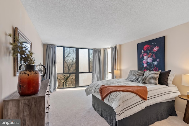 bedroom with expansive windows, carpet, and a textured ceiling