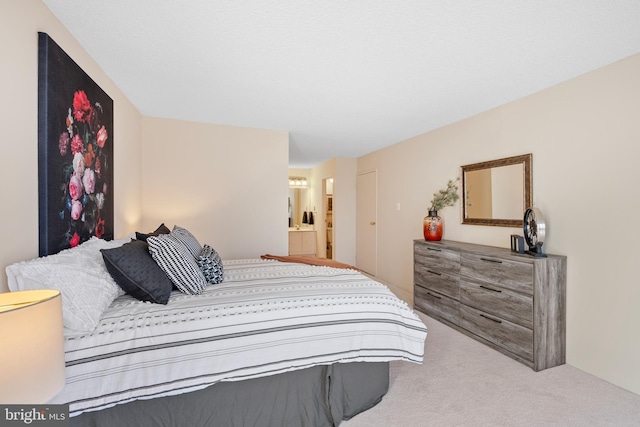 bedroom featuring ensuite bath and light colored carpet