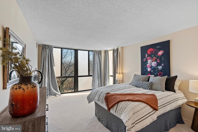 carpeted bedroom featuring floor to ceiling windows and a textured ceiling