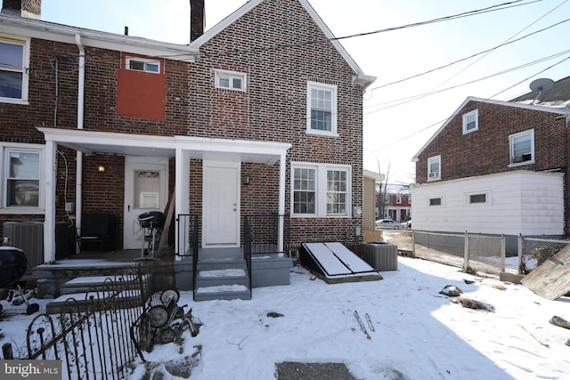 snow covered property featuring cooling unit