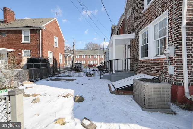 snowy yard featuring central air condition unit