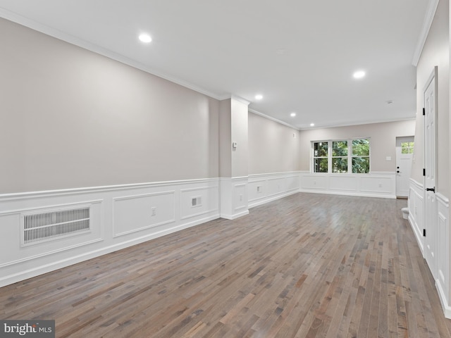 unfurnished room with hardwood / wood-style floors and crown molding