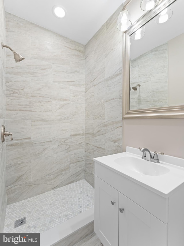 bathroom featuring vanity and tiled shower