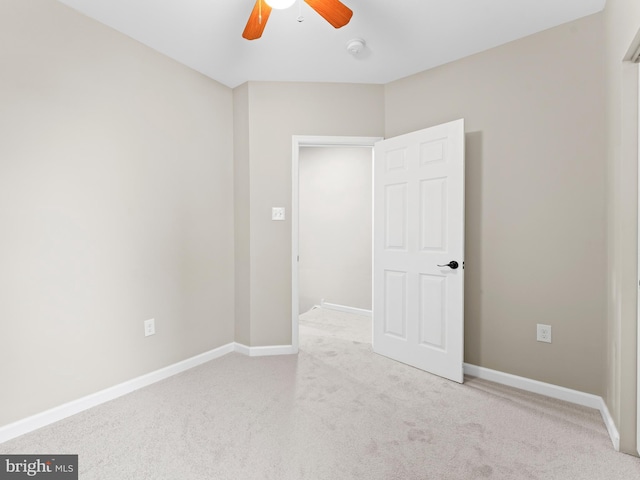 carpeted spare room featuring ceiling fan