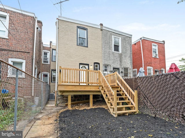 back of house featuring central air condition unit and a deck