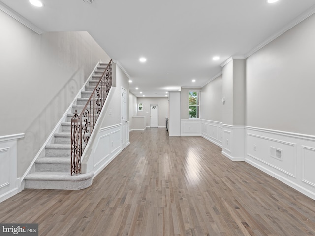 unfurnished living room with light hardwood / wood-style flooring and ornamental molding