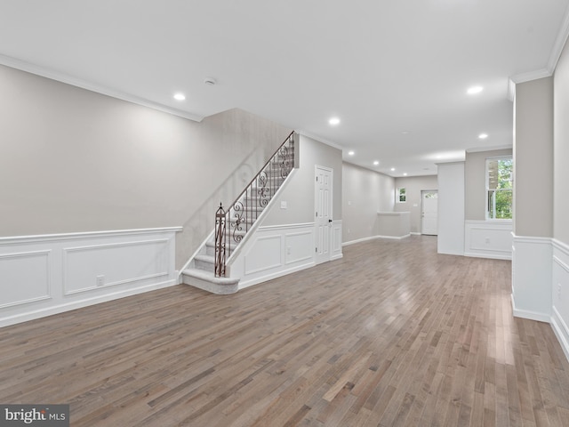 unfurnished living room featuring crown molding and wood-type flooring