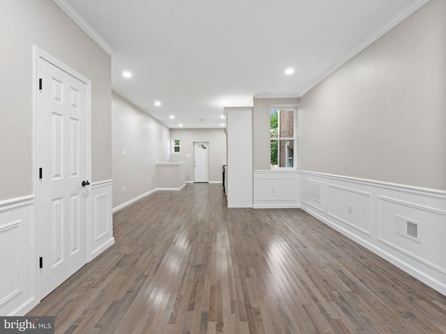 unfurnished living room featuring crown molding and wood-type flooring