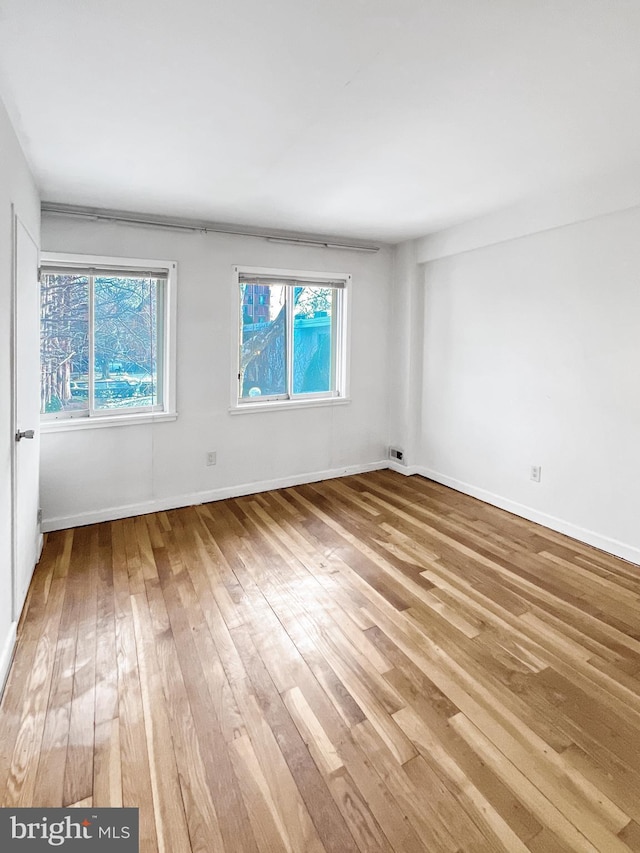 unfurnished room featuring hardwood / wood-style floors and a wealth of natural light