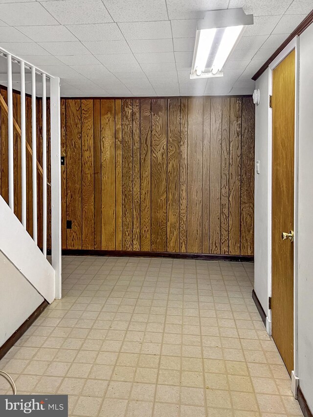 basement featuring wooden walls