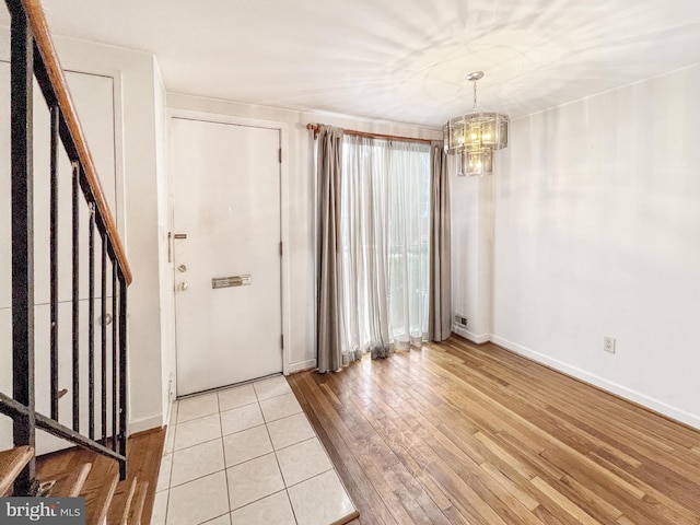 entryway featuring an inviting chandelier and light wood-type flooring