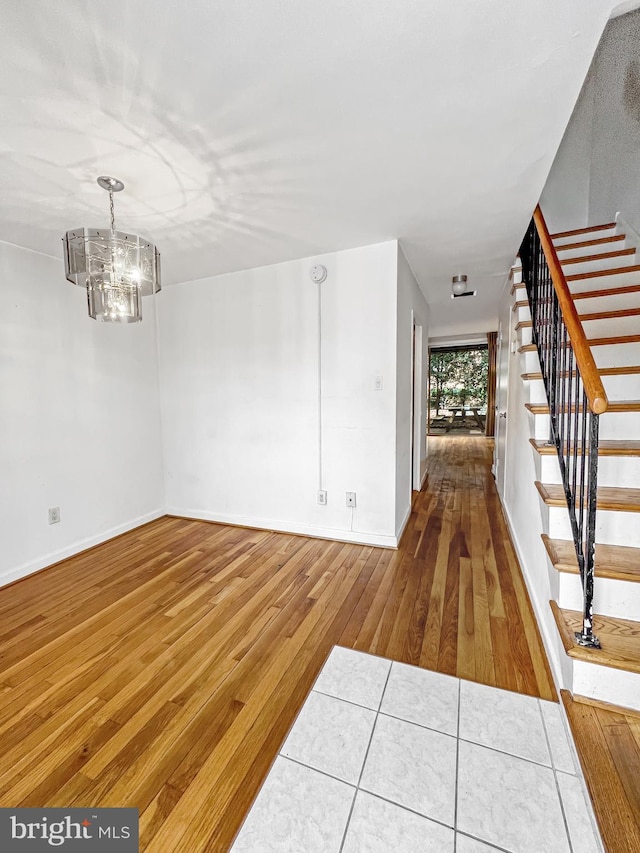 unfurnished room featuring hardwood / wood-style flooring and a notable chandelier