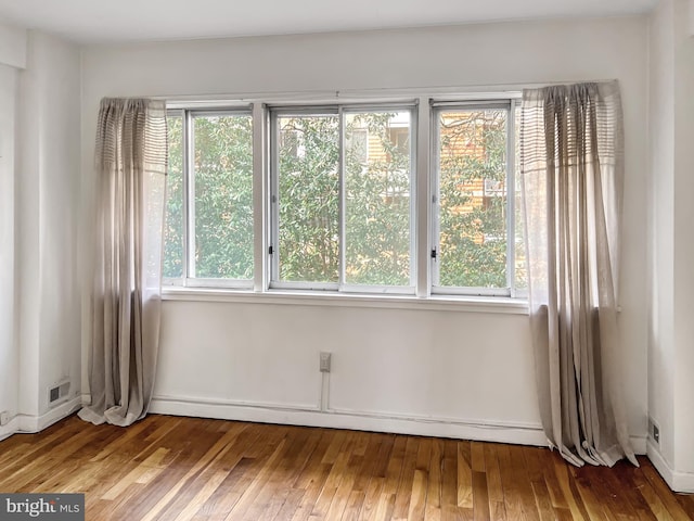 spare room with baseboard heating and hardwood / wood-style floors