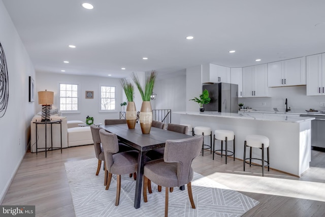 dining room featuring sink and light wood-type flooring