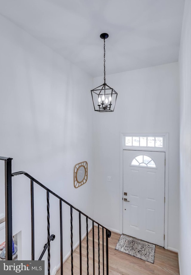 entryway featuring an inviting chandelier and light hardwood / wood-style flooring